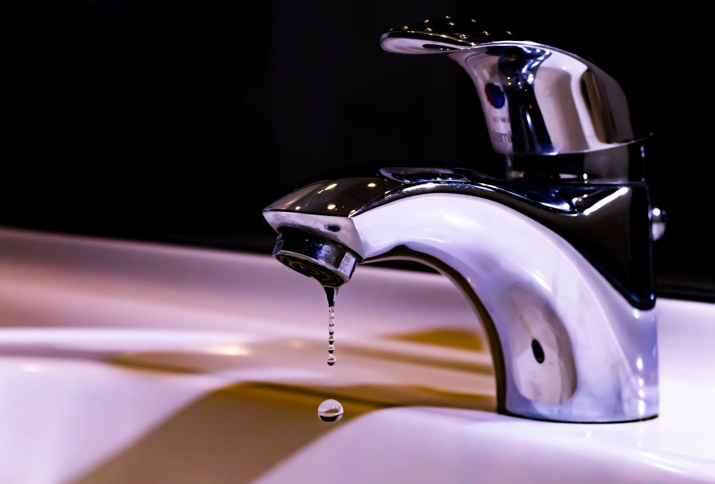 Faucet with a water drop about to fall
